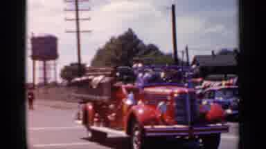 Mineola New York (1966): Fire Truck Leads A Baton Twirling Team Down The Street In
