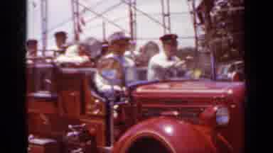 Mineola New York (1966): Well Dressed Fireman Ride On A Truck Through A Local