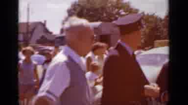 Mineola New York (1966): People Wearing Black Suits Stand Next To White Car On A
