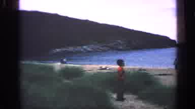 Massachusetts USA (1968): Person Boy Plays On Beach While Others Walk Around By