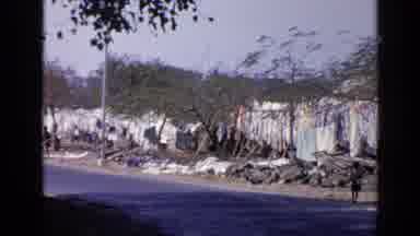India (1970): People Outside Next To A Road With What Looks Like Fences