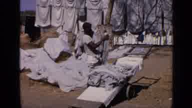 India (1970): A Person Outside Piles Laundry On Their Shoulder And Back
