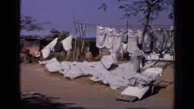 India (1970): Washing Clothes Outside At A Commune Camp Community Group Clear Blue