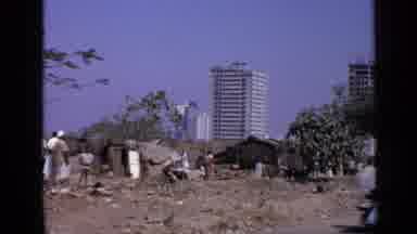 India (1970): Poor Dark Skinned People Outside Near Dirt Road