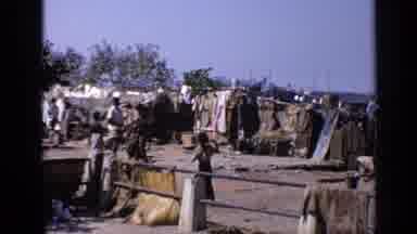 India (1970): A Community Of People Living In Poverty At The Edge Of A River On