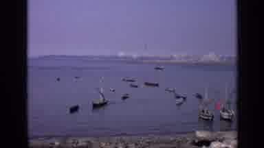 India (1970): Ocean Bay With Boats Fishermen Tying Nets Large Cityscape In