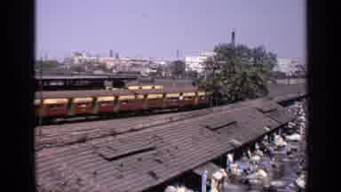 India (1970): Passing Brown And Yellow Train On A Sunny Day