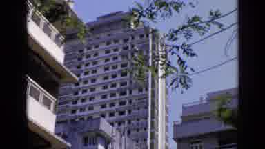 India (1970): Fast Old Light Blue Car Passing High White Pale Old Building