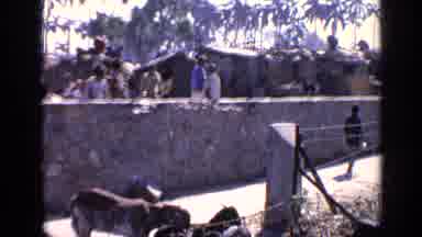 India (1970): Several People In A Village Walking Towards The Same Direction