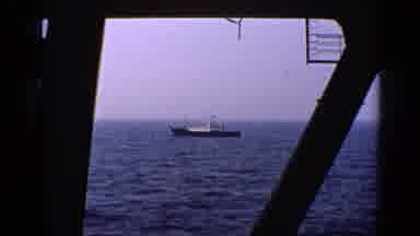 United Kingdom (1970): A Boat In The Ocean Has Men Working Inside It