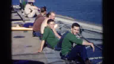 CUBA-1962: Several Sailors Sitting On Ship Deck With Ocean And Coastline In Background