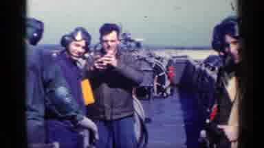 CUBA-1962: Men Gather On Aircraft Carrier Deck With Ear Protection And Camera