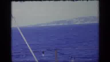 Italy (1962): Dark Blue Calm Waters Near Light Posts With Scenic Mountains In