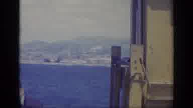 Italy (1962): Man And Metallic Object In Front Of A Blue Sea And Shoreline With