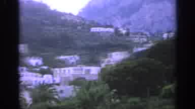 Italy (1962): White Buildings On A Rocky Hillside That Is Covered In Foliage