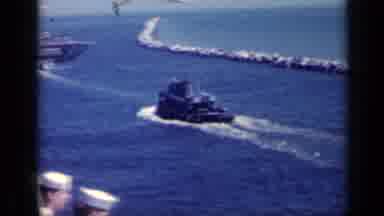 Italy (1962): Naval Men Watch Two Tugboats Move Through A Harbor Near A Jetty
