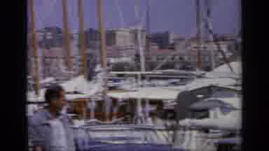 Greece (1963): Lots Of Boats In S Harbor As People Roam Around And Sailors Walk On