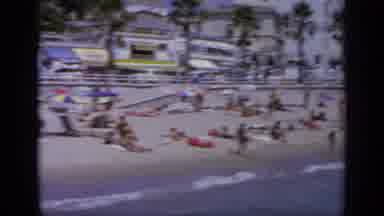Greece (1963): Sunbathers Lying On White Beach And Playing In Water On A Bright