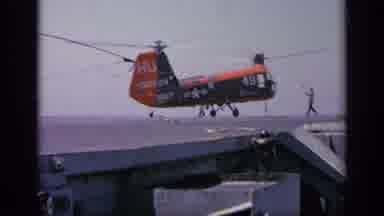 Greece (1963): Workers Helping Big Red Chopper Landing On Gray Street