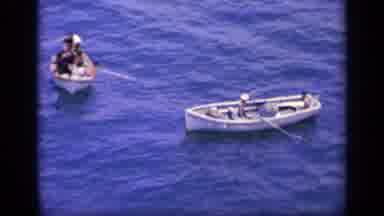 Greece (1963): Three Small Boats With People Rowing Them In The Ocean