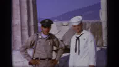 Greece (1963): Man Wearing White Naval Uniform Stands Next To Man Wearing Tan