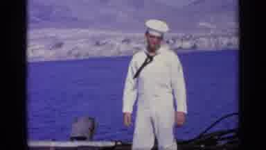 Greece (1963): Sailor Wearing White Uniform Smiling And Pointing At Coastline With