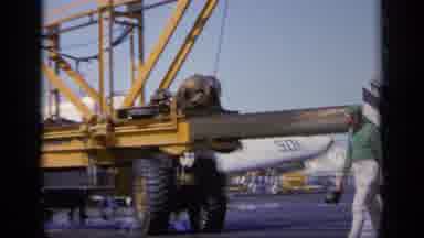GREECE-1963: Men Walk Past Large Yellow Aircraft Catapult On Airfield
