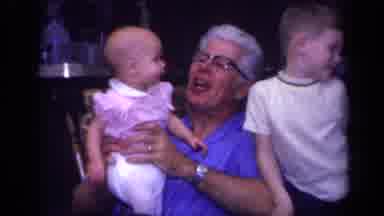 California USA (1968): White Haired Man In Glasses Holding Two Small Children In A