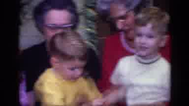 California USA (1968): A Mother In A Pink Dress Surrounded By Family Members
