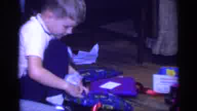 California USA (1968): A Boy Opening His Gifts And A Small Girl Sitting In Her