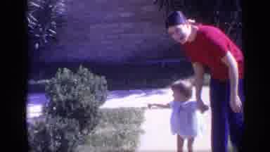 California USA (1968): Mom Walking On The Sidewalk With Baby Girl On A Sunny Day