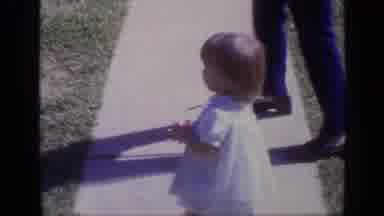 California USA (1968): Little Kid Playing On The Sidewalk Walking Towards The