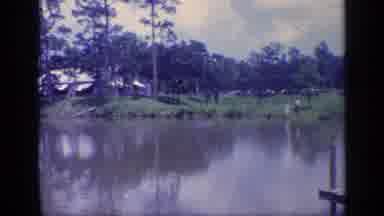Florida USA (1968): Trees Homes And Piers On The Riverbank Surround A Smooth Muddy