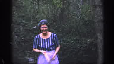 Florida USA (1968): Elderly Lady In Dress And Apron Walks Towards Camera Holding