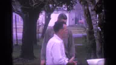 Florida USA (1968): Older Man Leads Younger Man Around Vehicle As They Inspect It