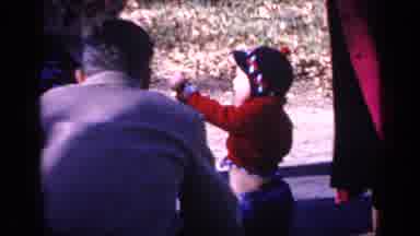 Florida USA (1968): Woman Wearing White Robe Laughs At Toddler Wearing Red Sweater