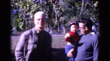 Florida USA (1968): Two Gum Chewing Men And A Young Child Watch Another Man Run