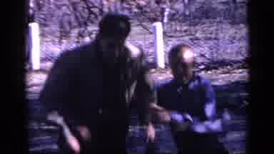 Florida USA (1968): Woman Wearing Black Jacket Walks Past Camera On A Bright Sunny