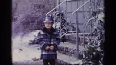 California USA (1969): Little Boy Bundled Up For The Weather Waves To Camera