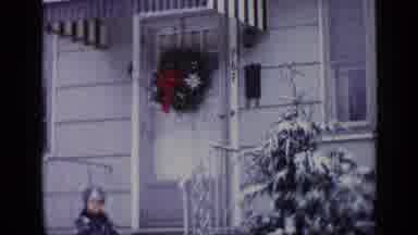 California USA (1969): Child Waiting Outside On Christmas To Play In The Snow