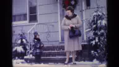 California USA (1969): Mother And Son In Front Of House In The Snow