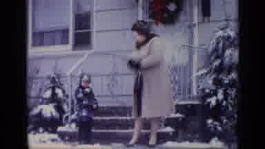 California USA (1969): Woman Puts On Gloves Then Points Up For Little Boy To Look
