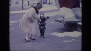 California USA (1969): A Women And A Boy Stand Playing In A Street Then A Little
