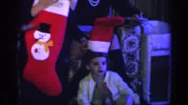California USA (1969): Kids Opening Presents From Stocking When One Wears It As A