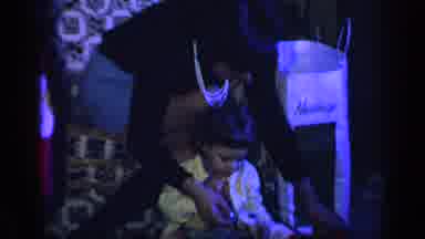 California USA (1969): Mom Helping Her Child Open Christmas Gifts During The