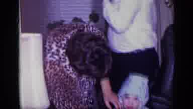 California USA (1969): Woman Wearing Black And Brown Dress Ties Hood Of Baby