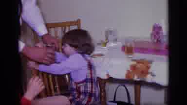 California USA (1969): Man Offering A Drink To A Little Boy Kneeling On A Chair At