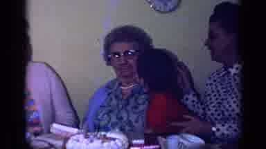 California USA (1969): Little Boy Gives Grandma Kiss On Check During Family