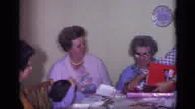 California USA (1969): Woman Wearing Blue Dress Sits Looking At Red Gift Box
