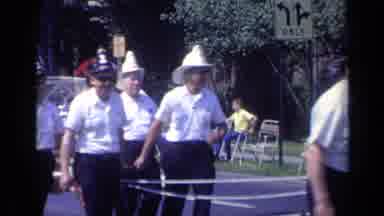 California USA (1969): A Firefighter Truck And Its Crew Are Marching Down The